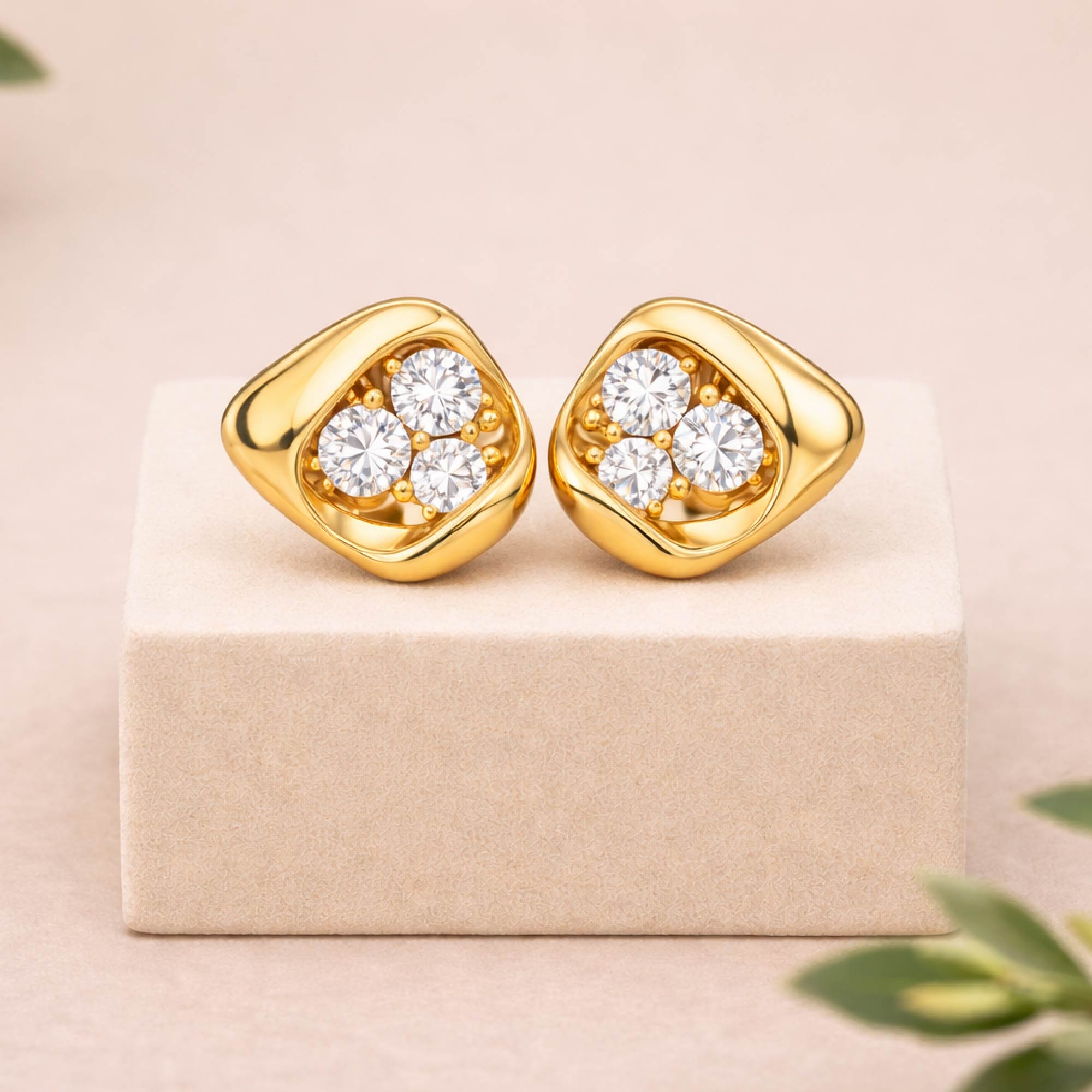 Gold earrings with diamonds on a beige box