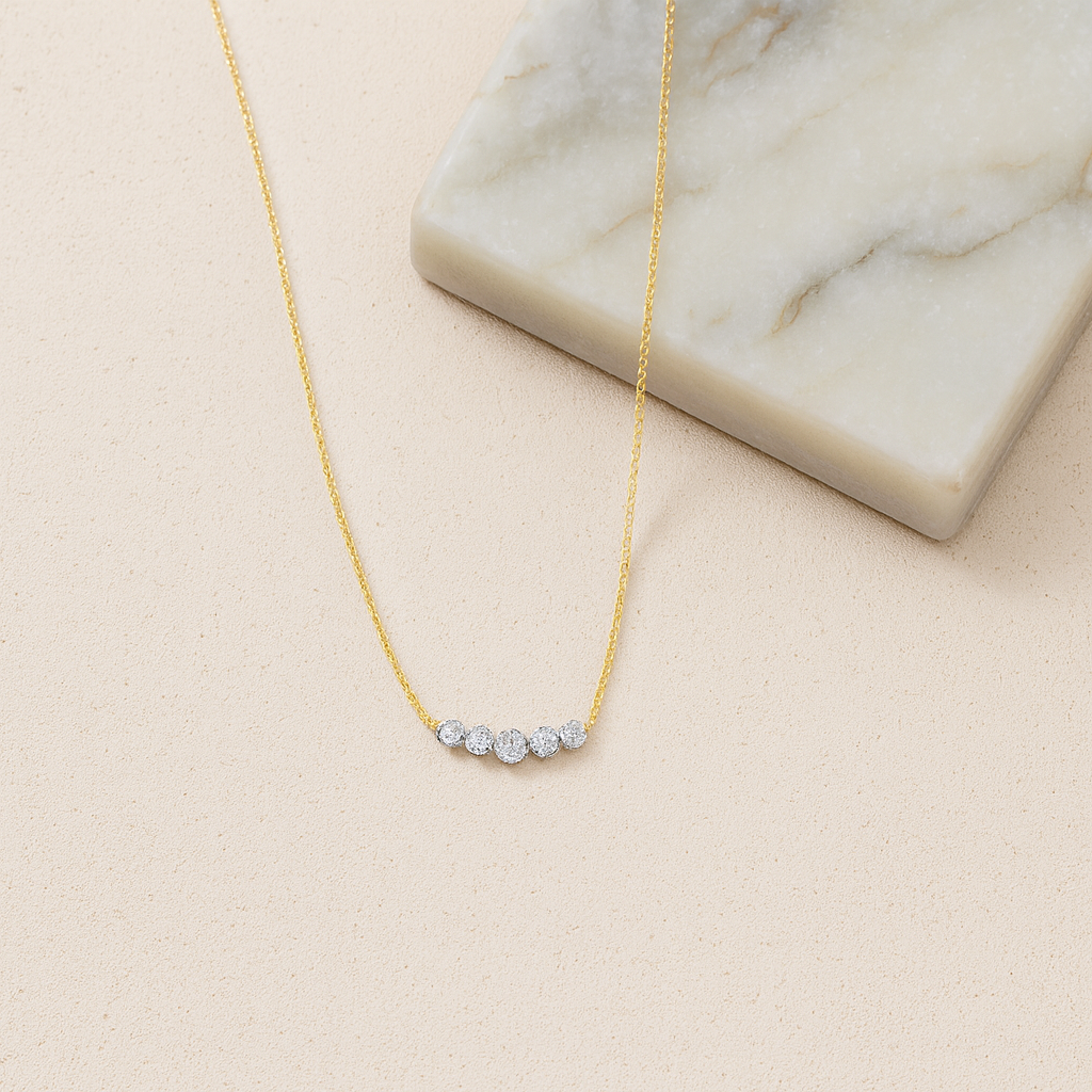 Gold necklace with small diamonds on a beige surface