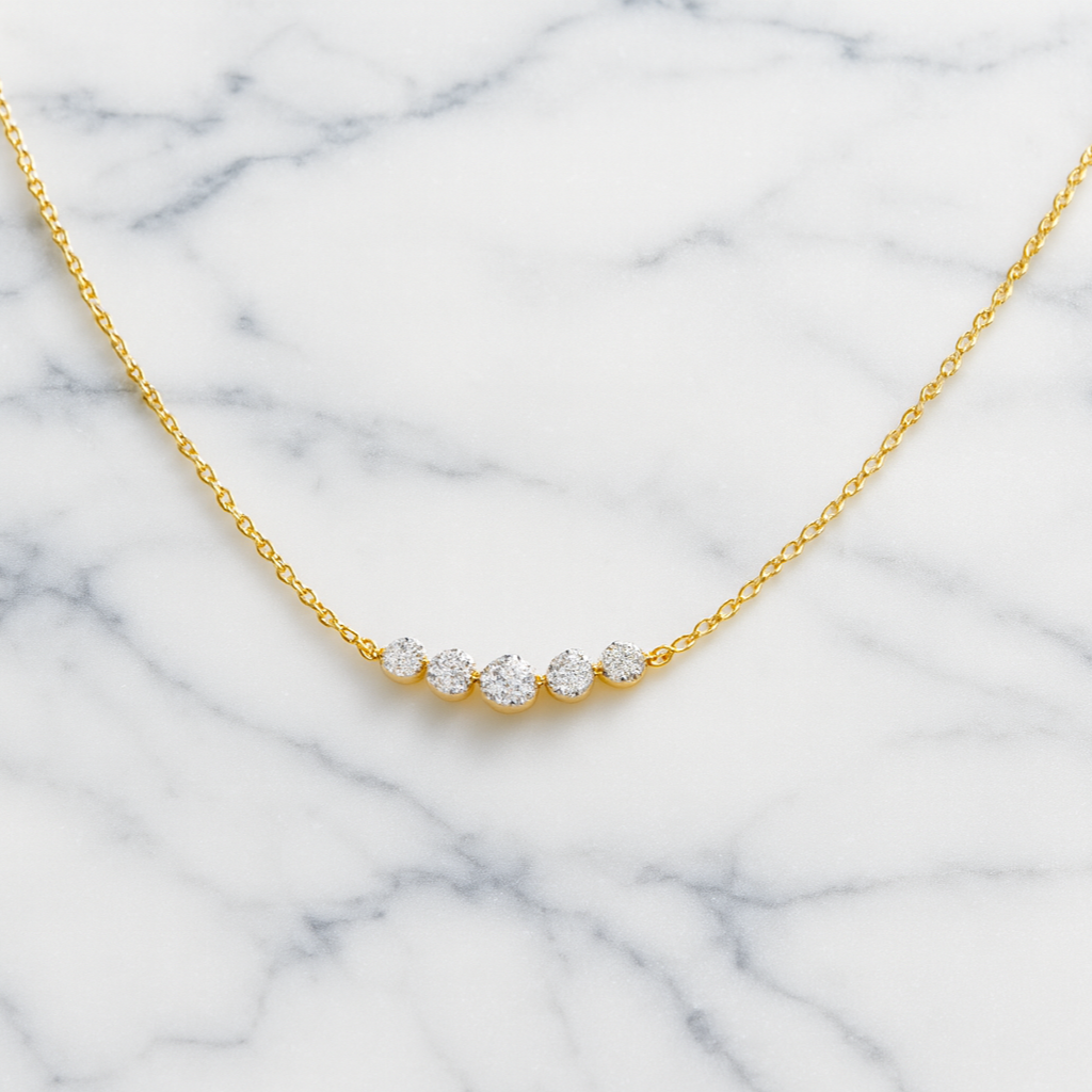 Gold necklace with small diamonds on a marble background