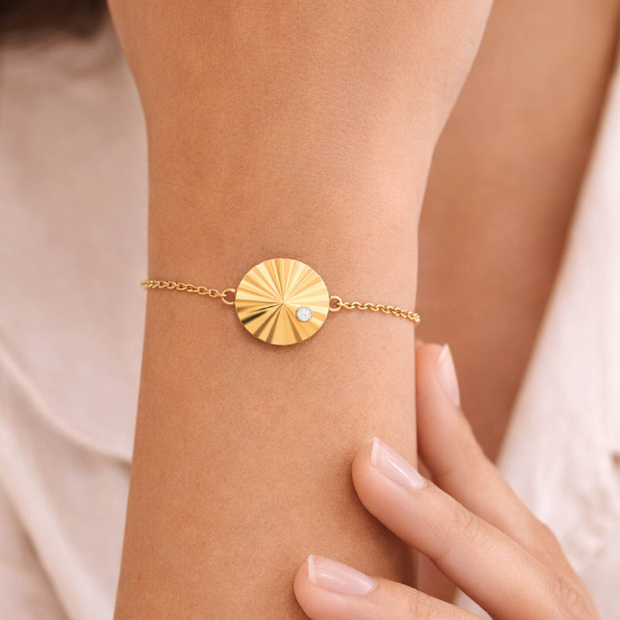 14k gold. vermeil bracelet with a circular pendant on a white background
