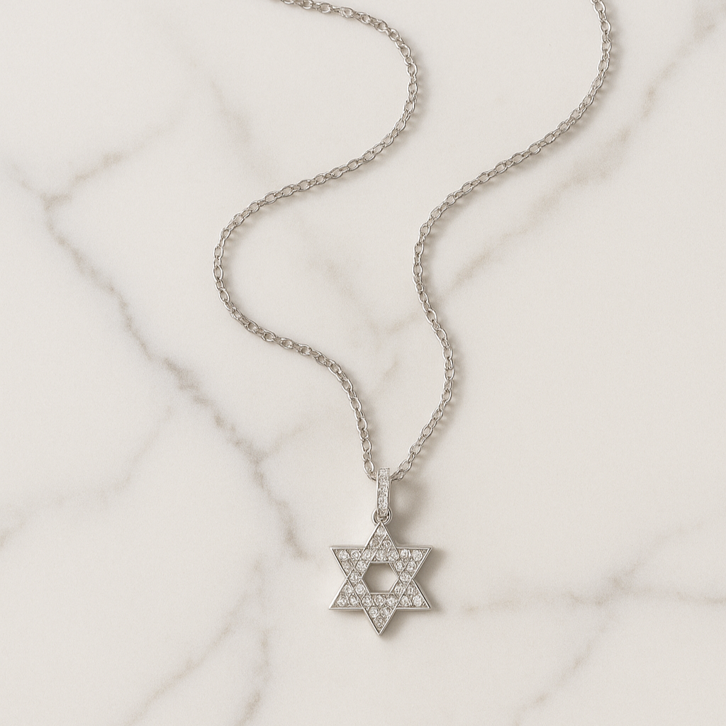 Silver necklace with a Star of David pendant on a light marble background