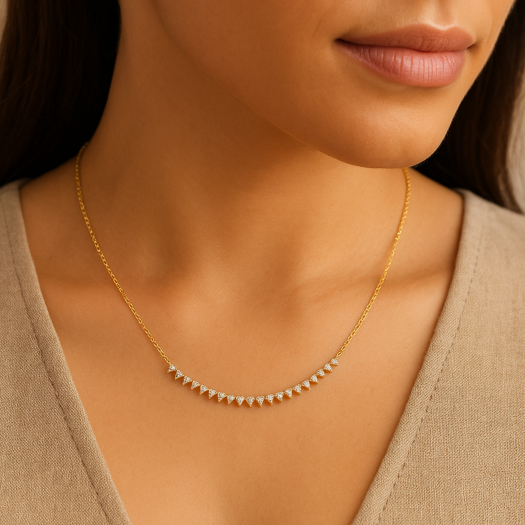 Gold necklace with small diamonds on a model wearing a beige top