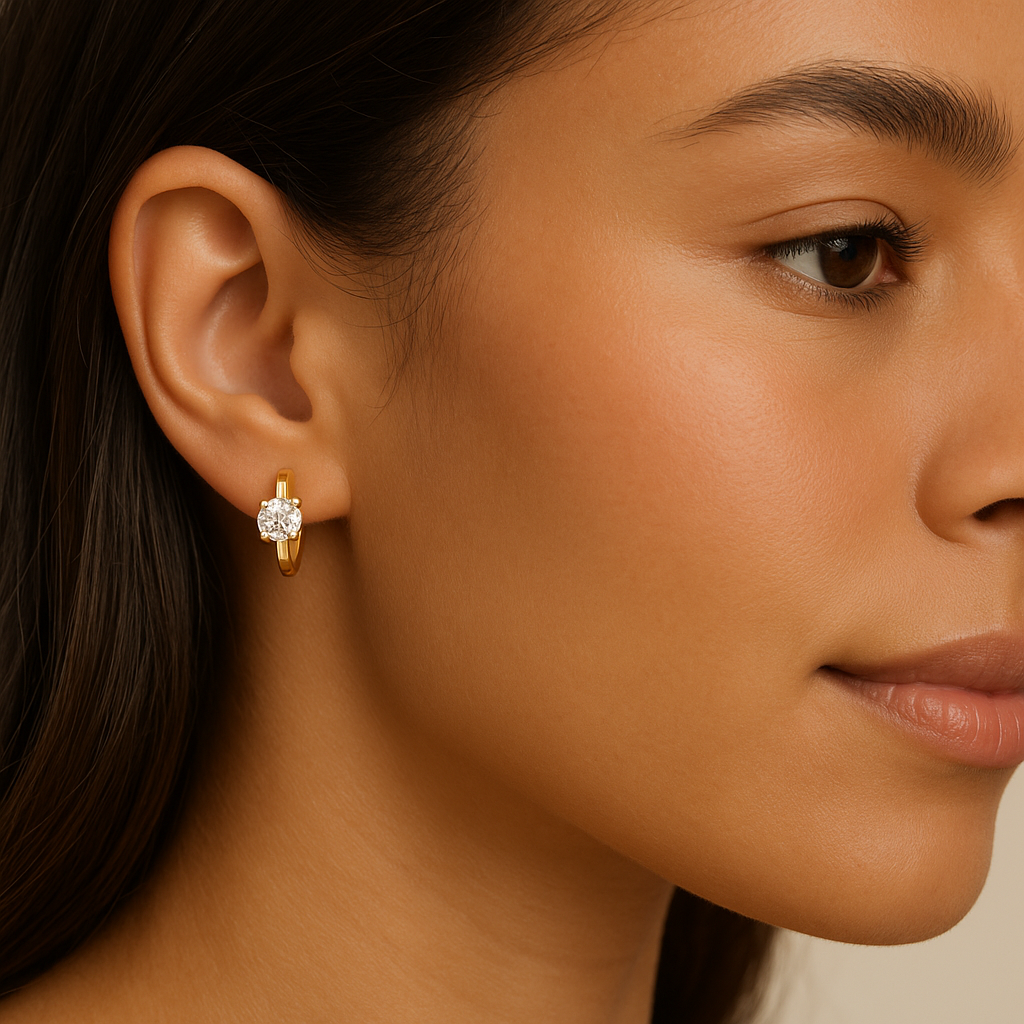 Close-up of a woman wearing gold earrings with a beige background