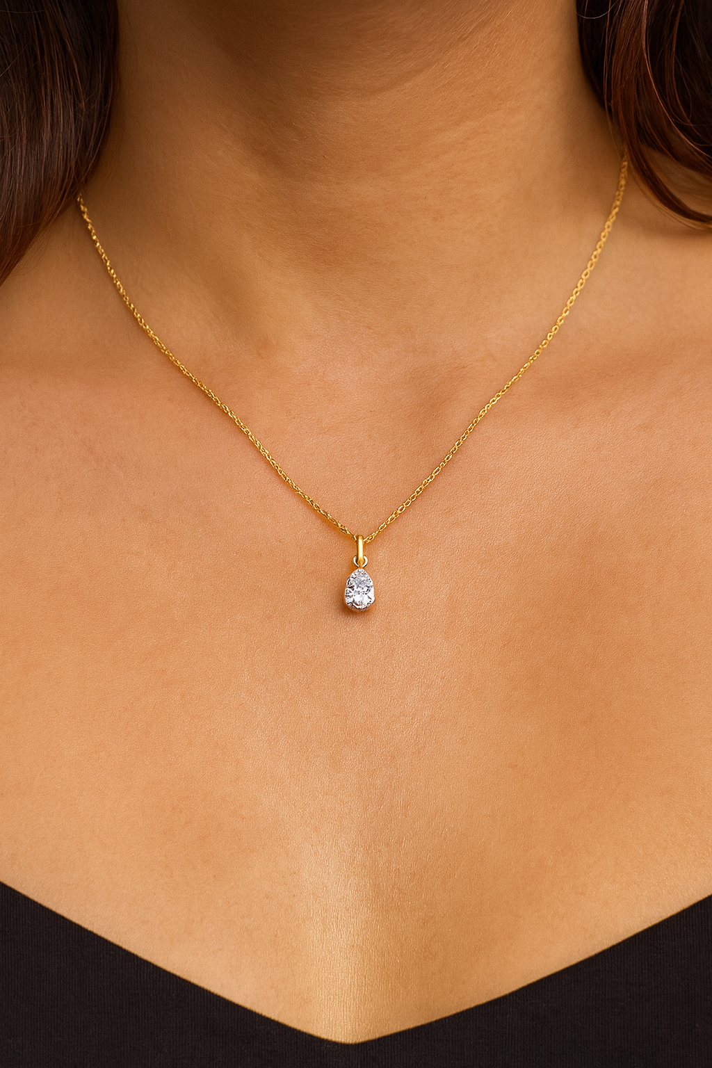 Gold necklace with a diamond pendant on a person's neck