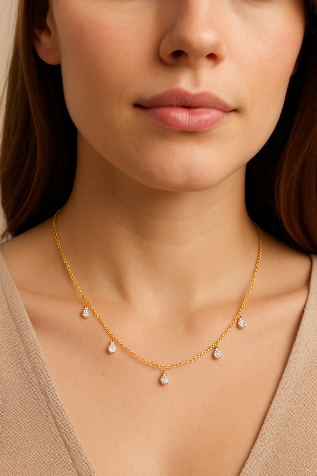 Close-up of a woman wearing a gold necklace with small diamonds.