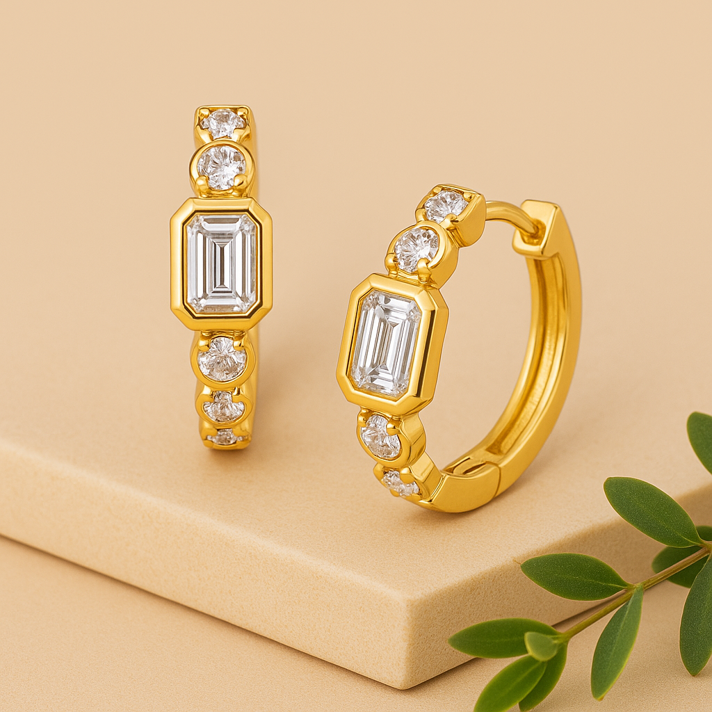 Gold hoop earrings with emerald-cut gemstones on a beige background