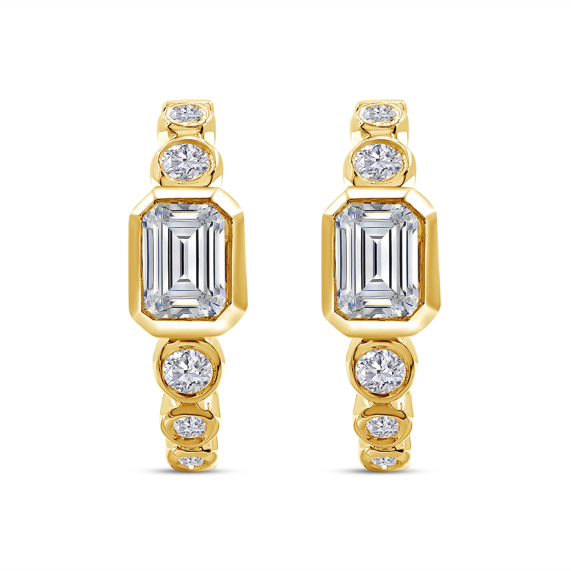 Gold earrings with emerald-cut and round gemstones on a white background