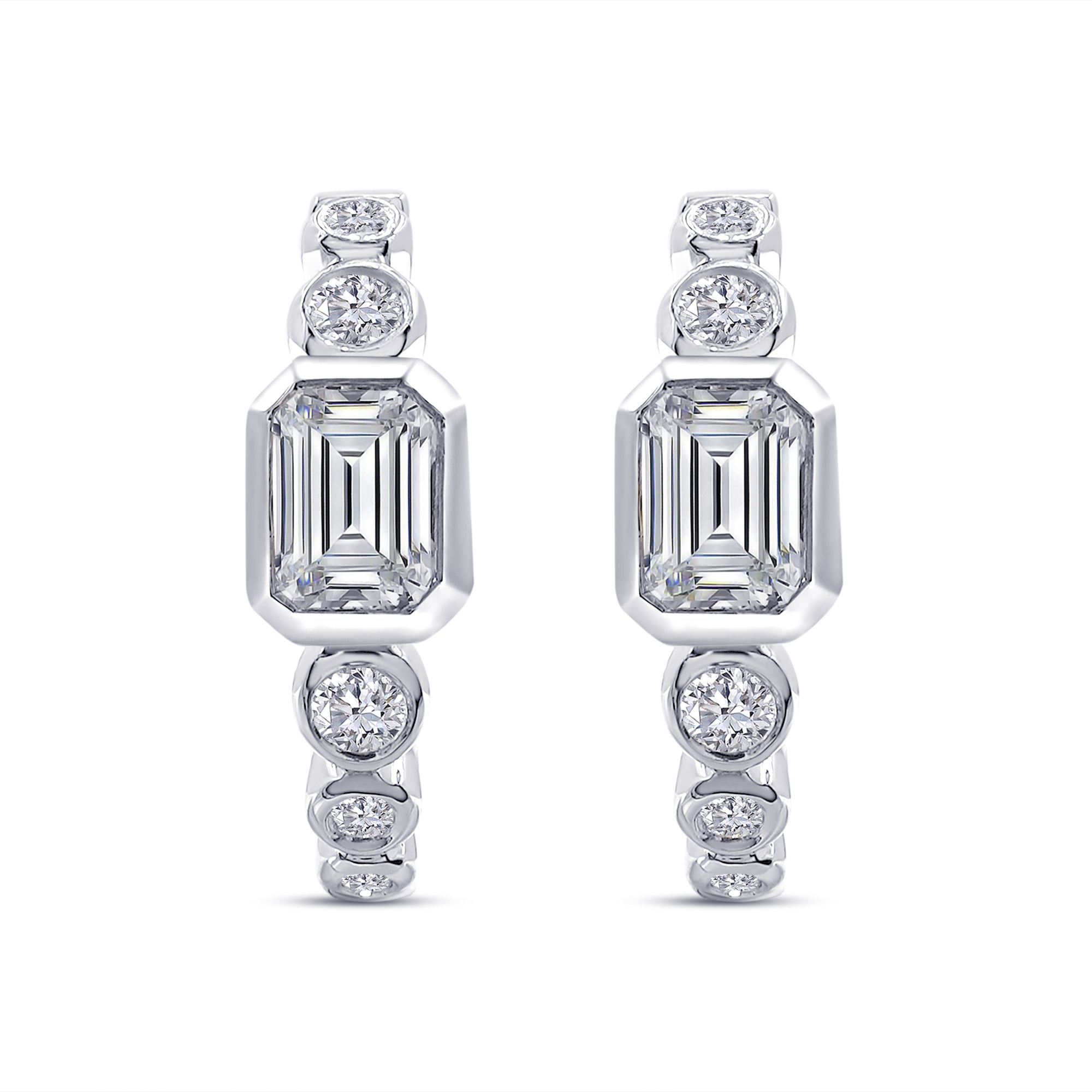 Diamond earrings with emerald-cut and round gemstones on a white background