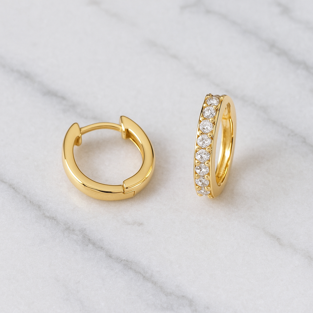Gold hoop earrings on a marble surface