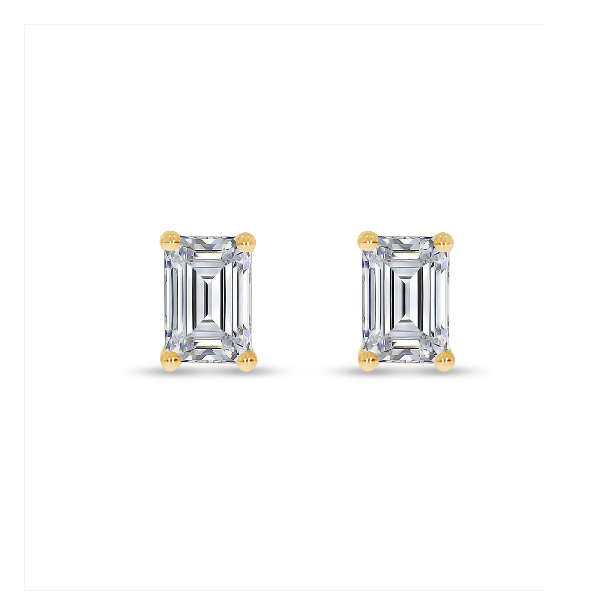 Pair of emerald-cut diamond earrings with gold prongs on a white background