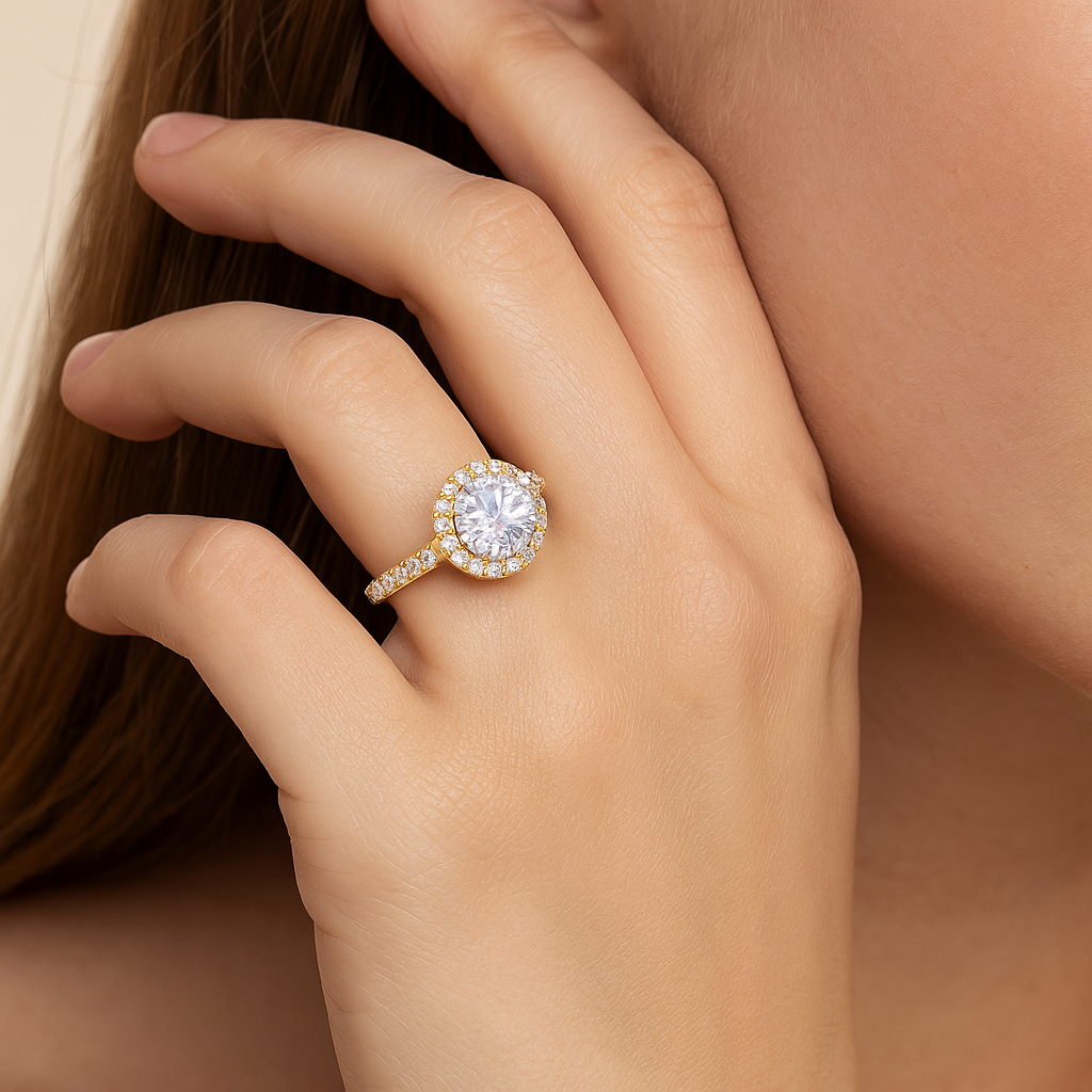 Gold ring with a large diamond on a hand against a neutral background