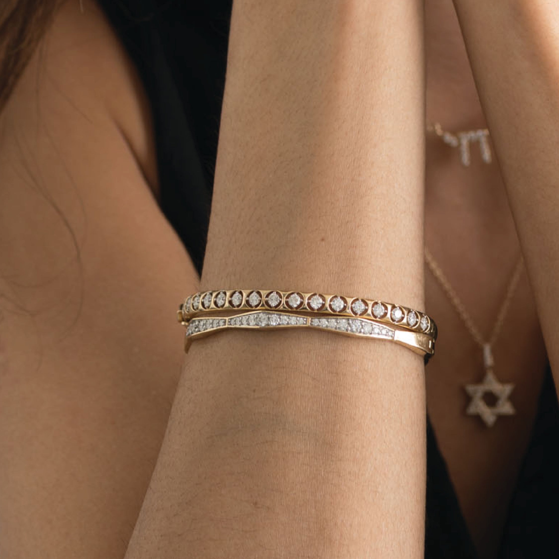 14K solid gold bangle bracelet with lab-grown diamonds on a woman's wrist.