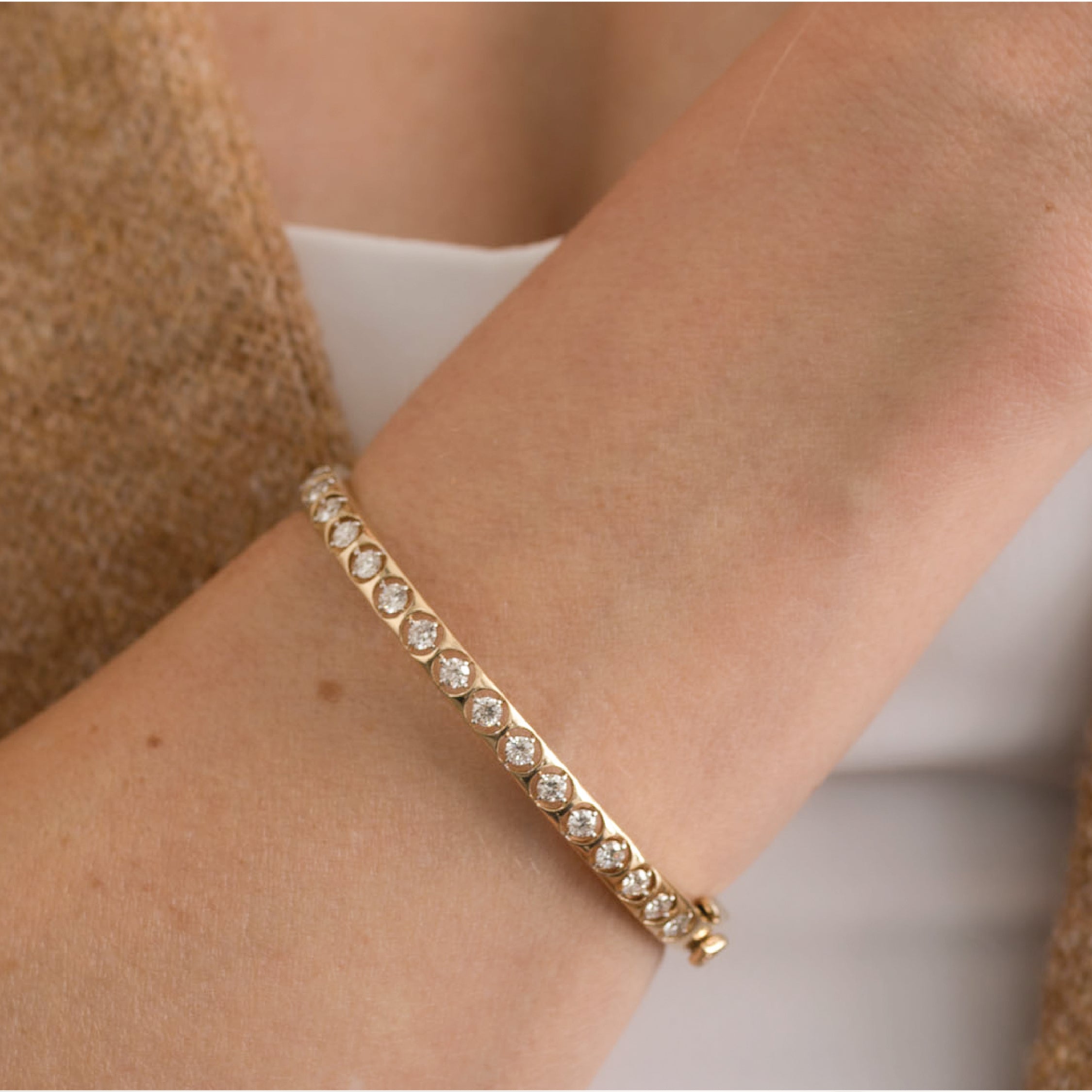 14K solid gold bangle bracelet with diamonds on a wrist, elegant and shiny.