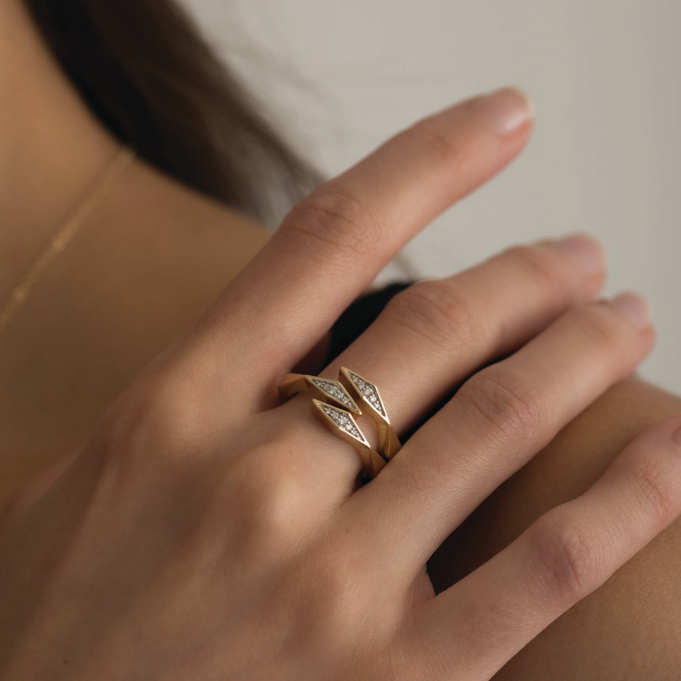 14K solid gold ring with lab-grown diamonds in a triple bypass design on a hand.