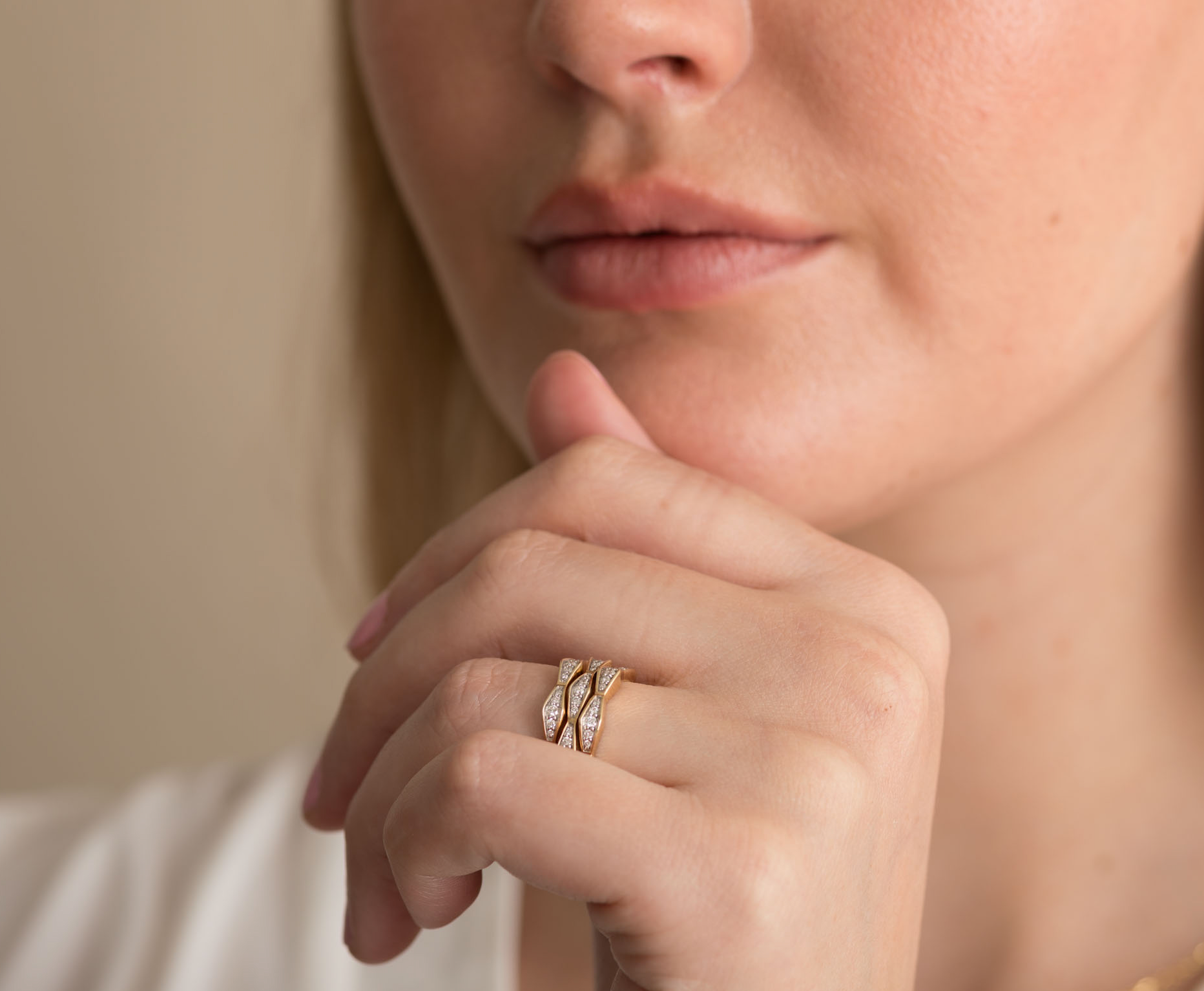 Close-up of a hand wearing a 14K solid gold diamond double stack ring with white diamonds.