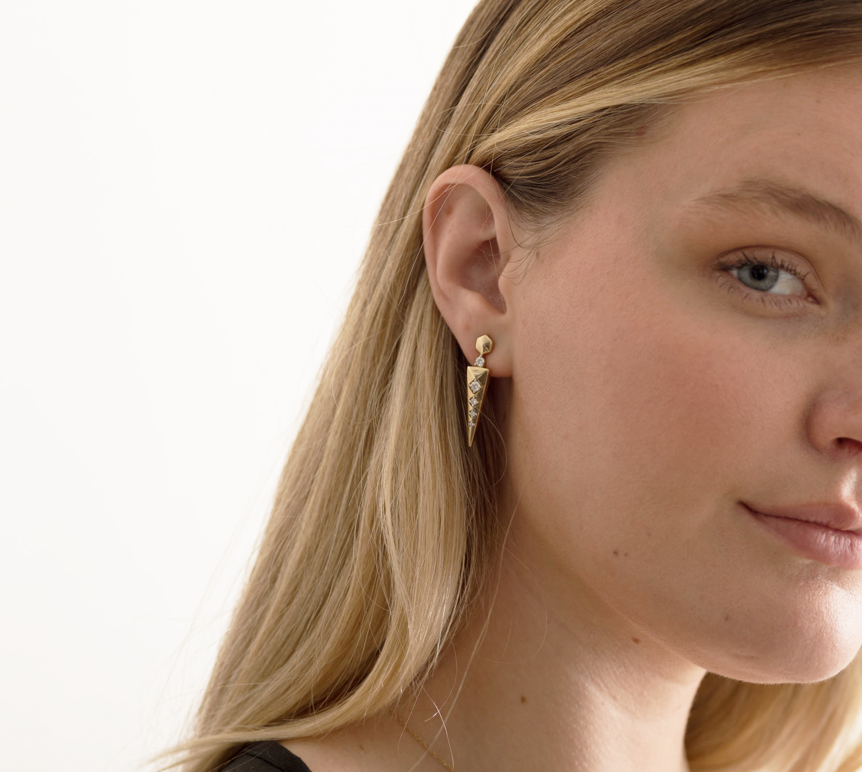 14K solid gold earrings with diamond accents on a woman's ear, showcasing elegant design.