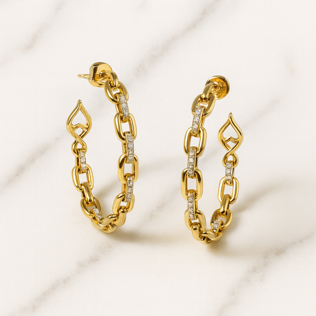 Gold chain earrings with diamond accents on a light background
