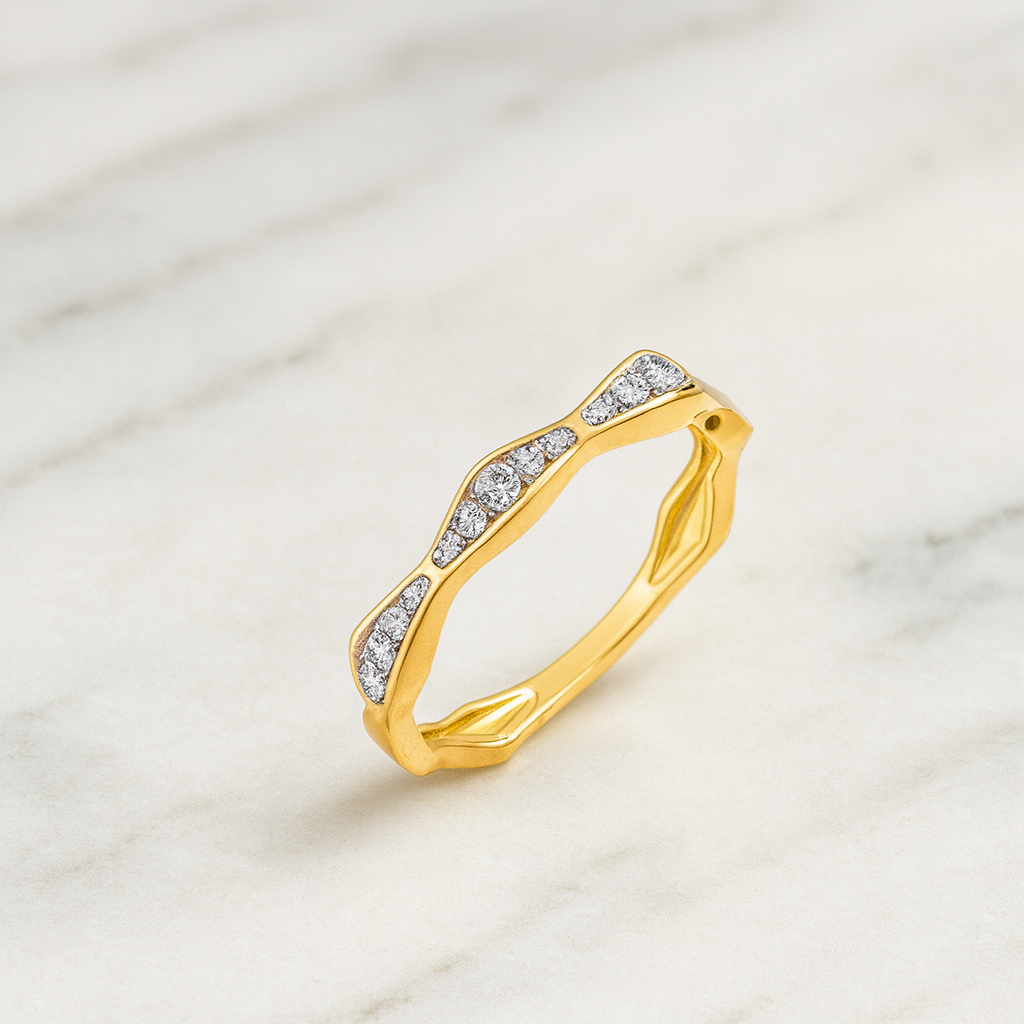 Gold ring with diamond accents on a marble surface