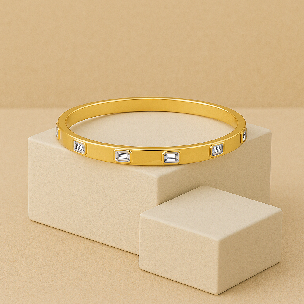 Gold bracelet with embedded stones on a beige stand against a beige background