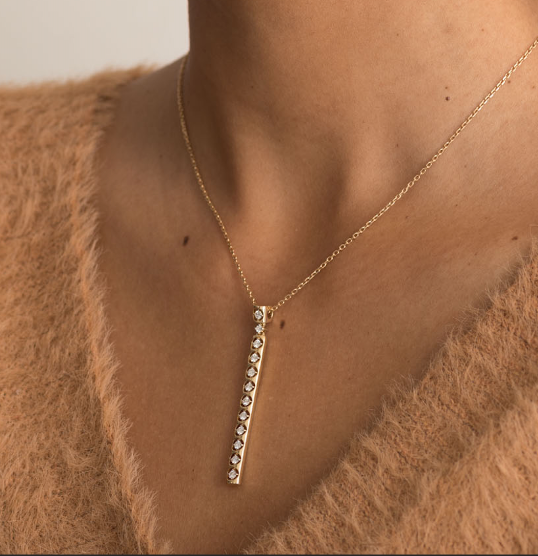 14K gold necklace with vertical diamond pendant on a delicate chain.