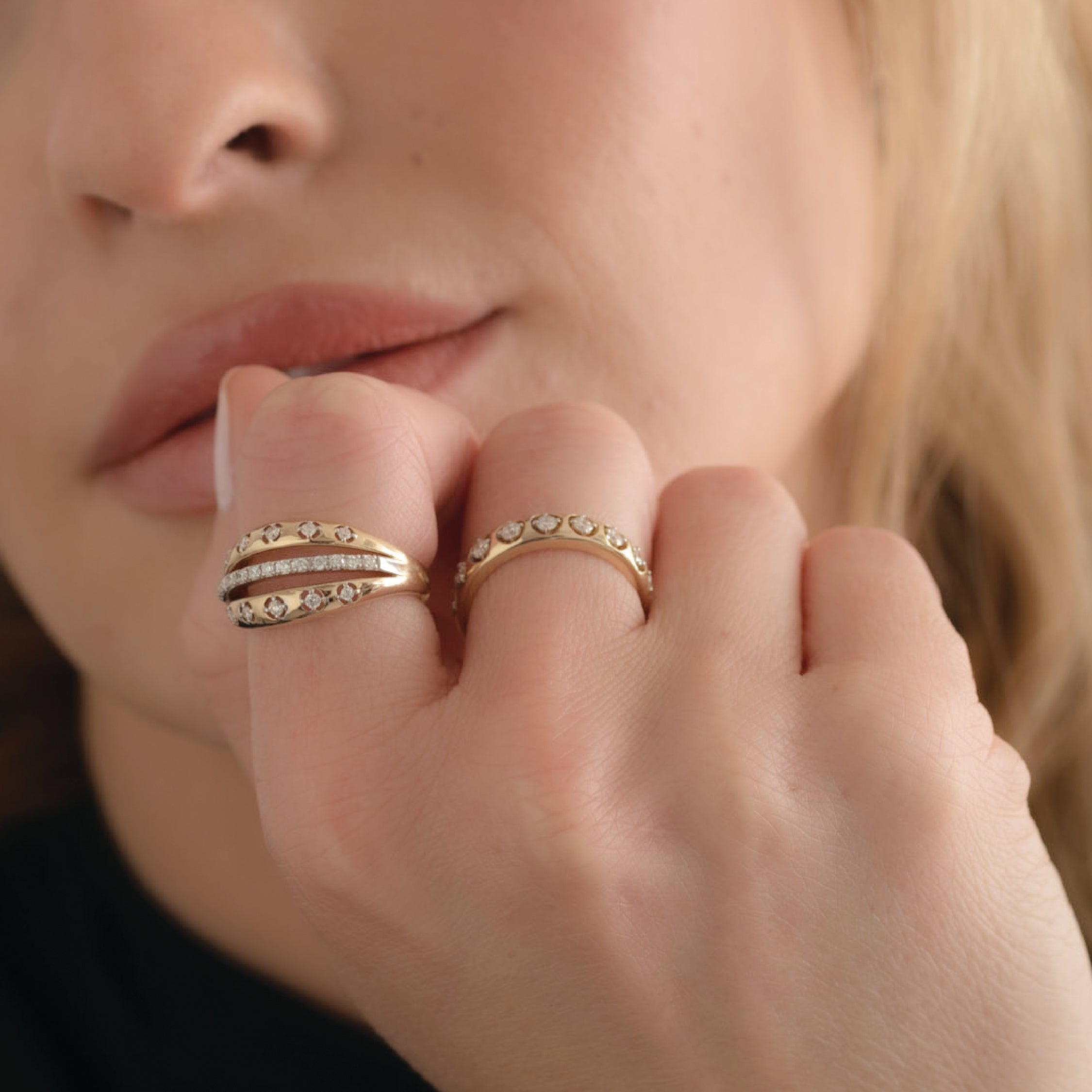 Close-up of a hand wearing a 14K solid gold ring with diamonds, showcasing elegant design.