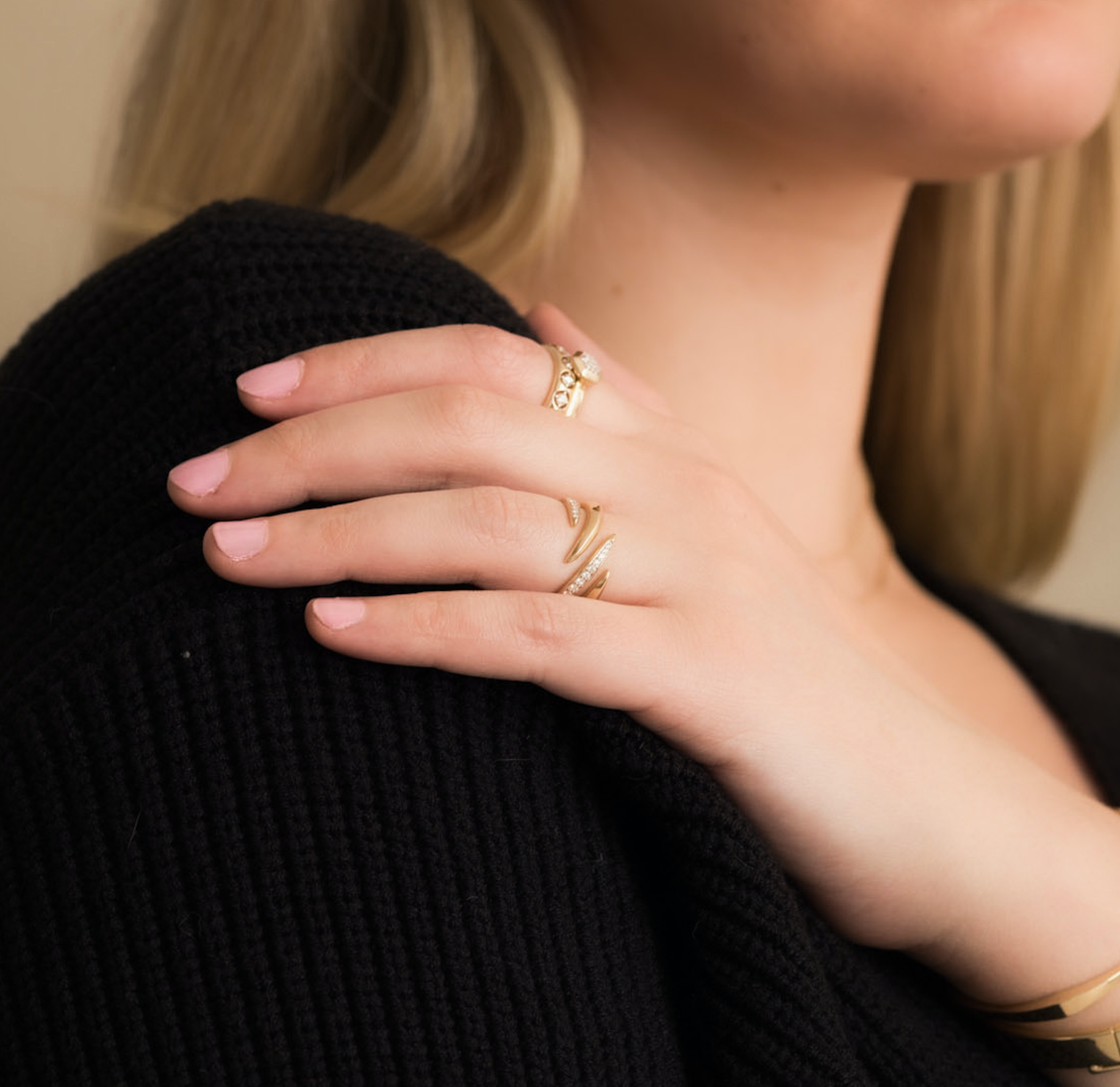 Woman wearing a 14K solid gold diamond ring with a swirl design on her hand.