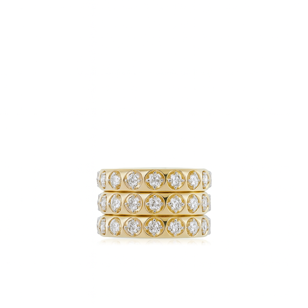 Stack of gold rings with diamond accents on a white background