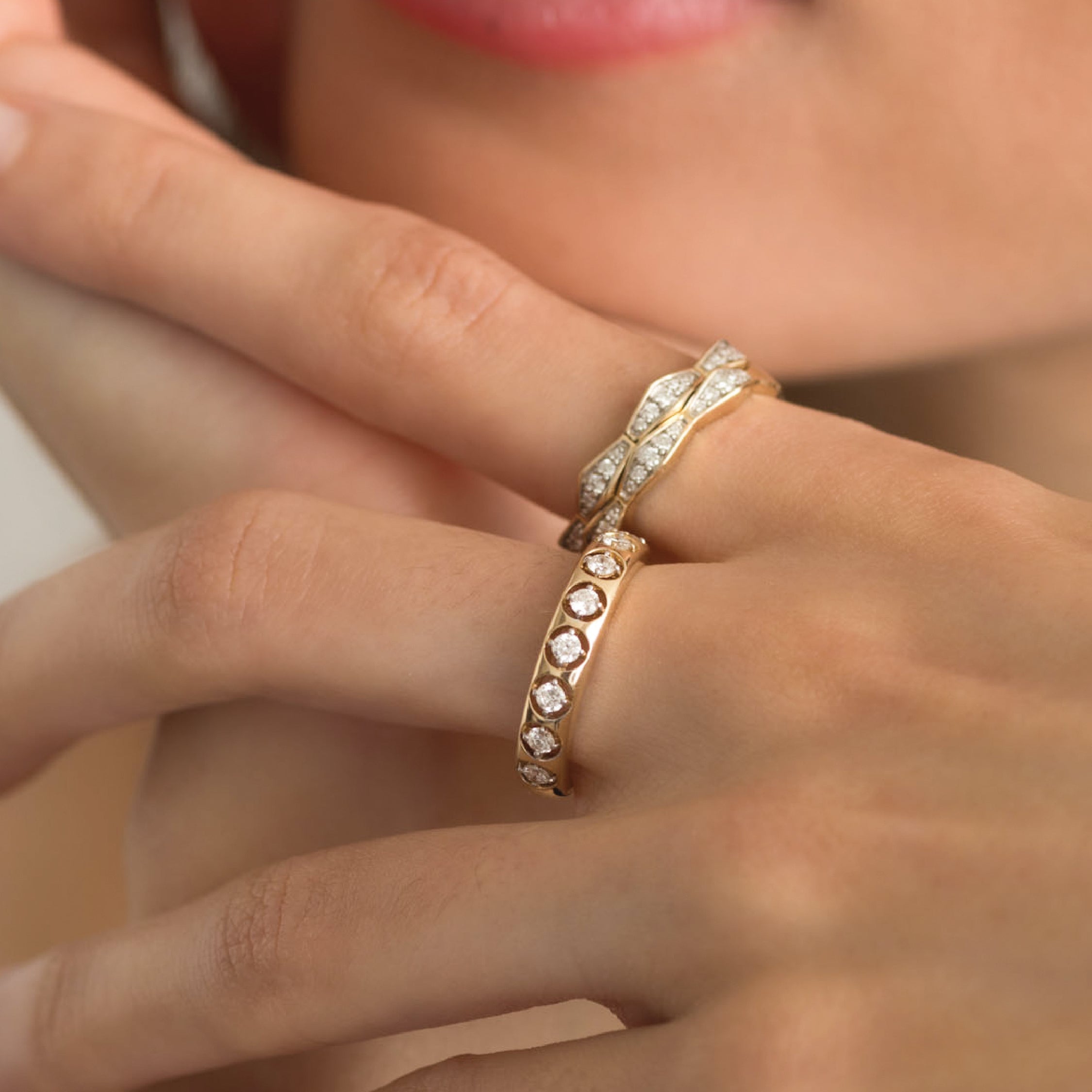 Close-up of a 14K gold ring with diamonds on a hand, showcasing elegant design.