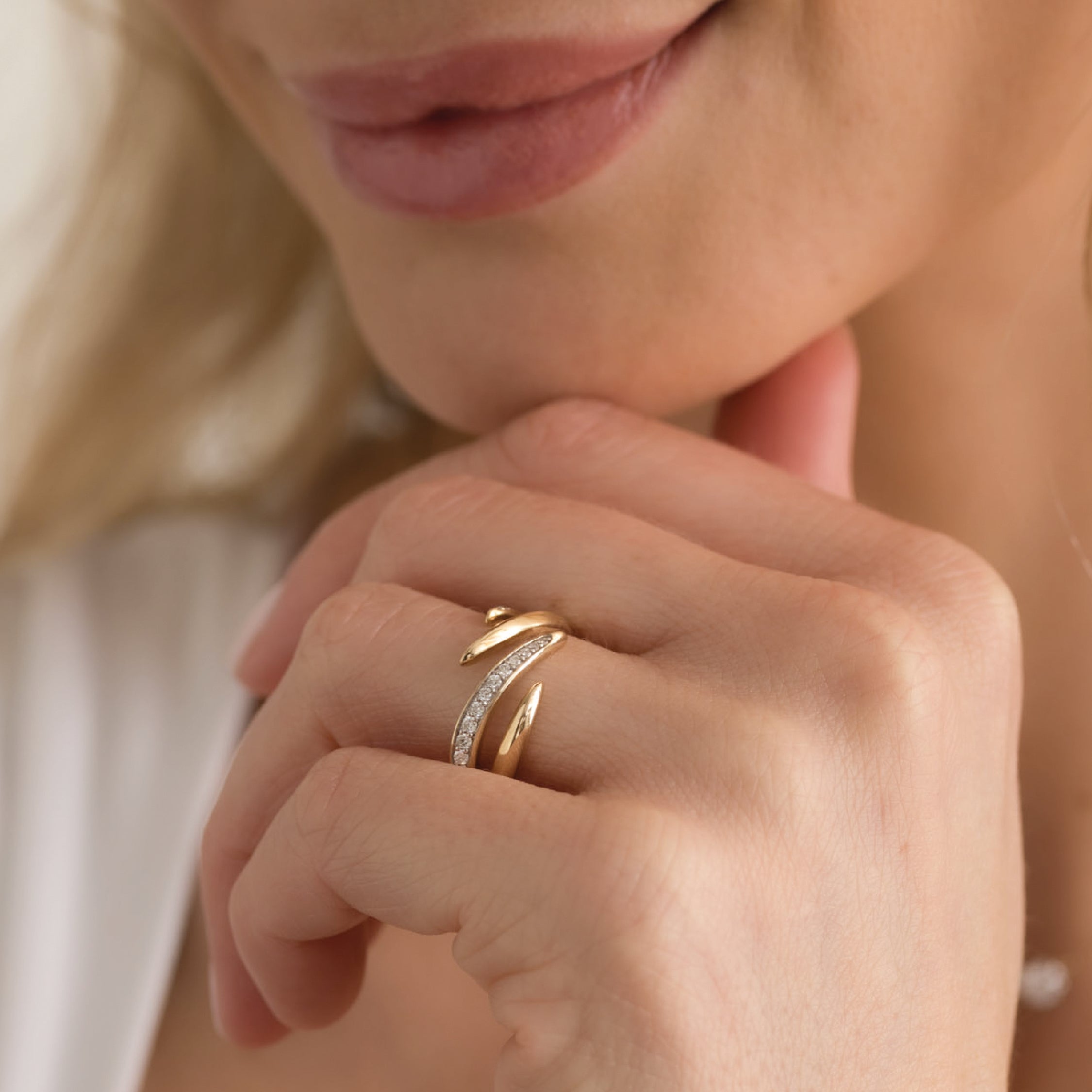 14K solid gold ring with a swirl design and diamonds on a woman's finger.
