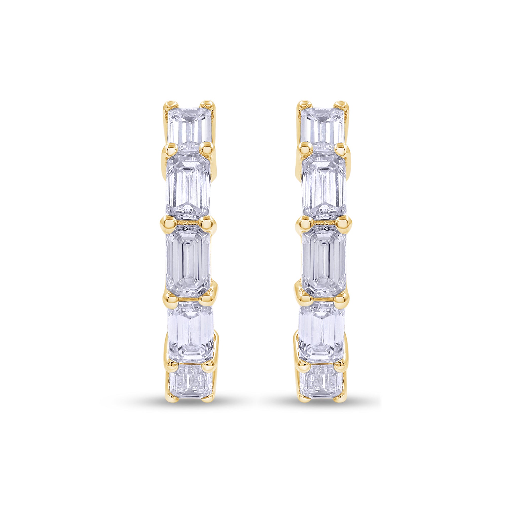 Gold earrings with emerald-cut gemstones on a white background