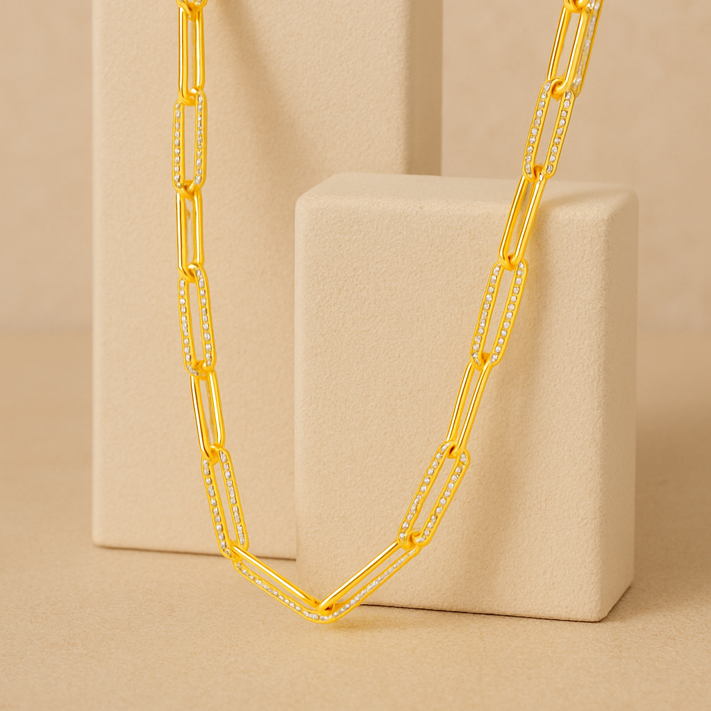 Gold chain necklace on a beige stand against a beige background