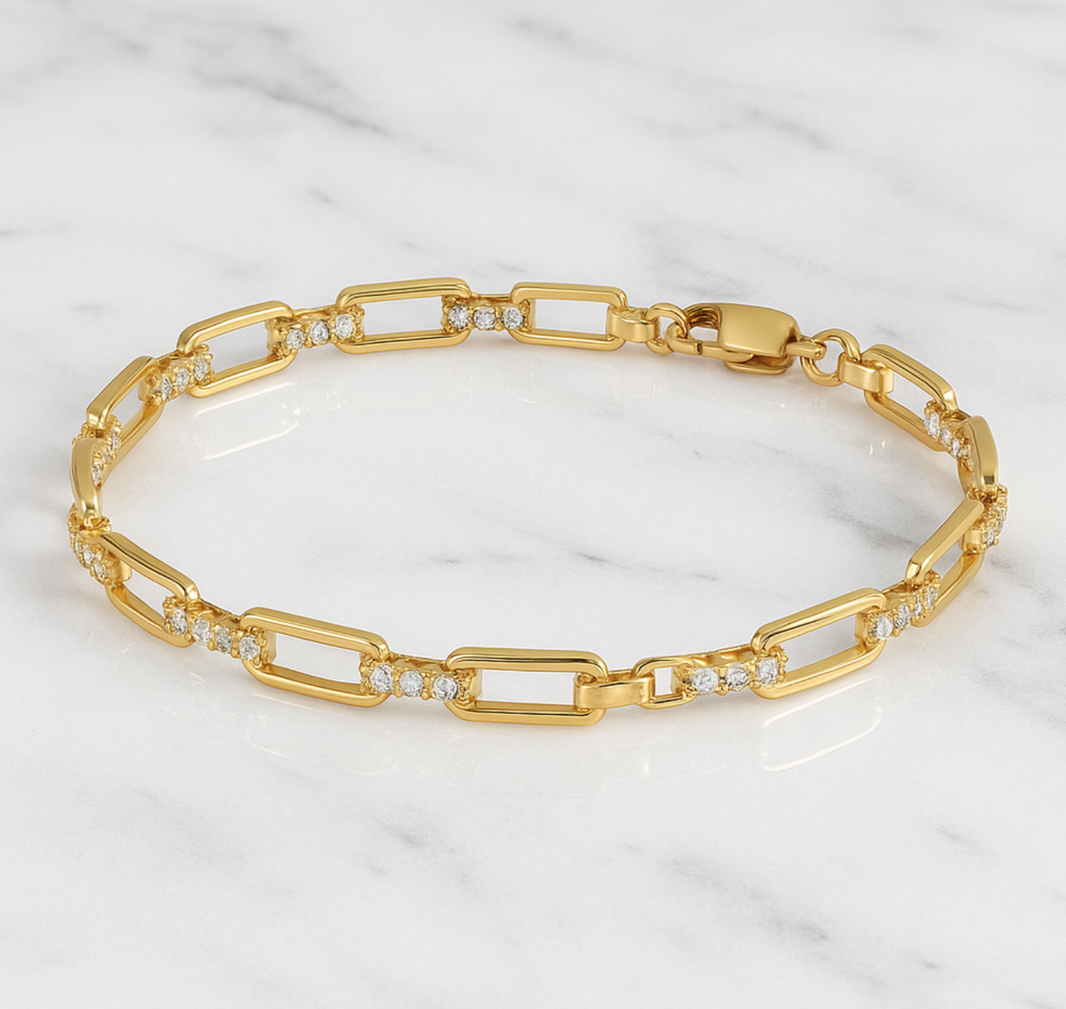 Gold bracelet with diamond accents on a marble surface