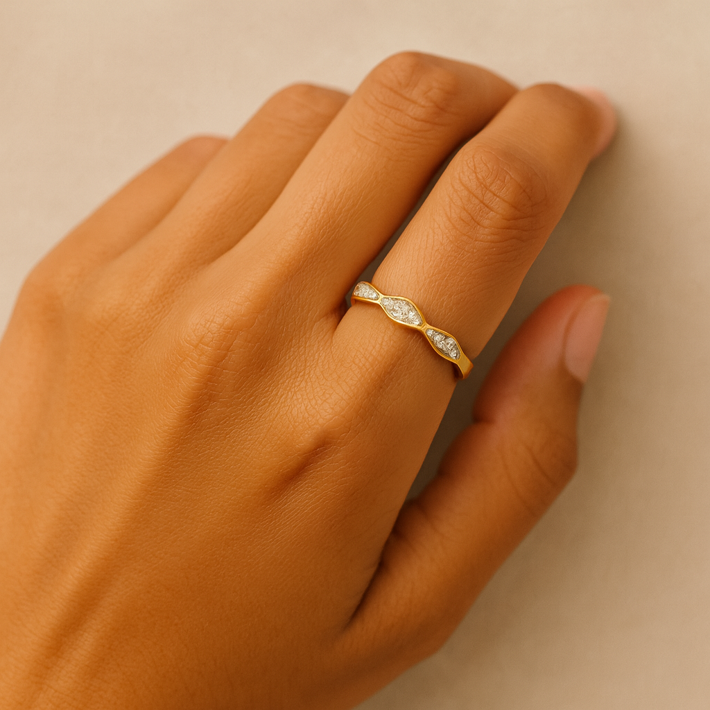 Gold ring with diamonds on a hand against a beige background