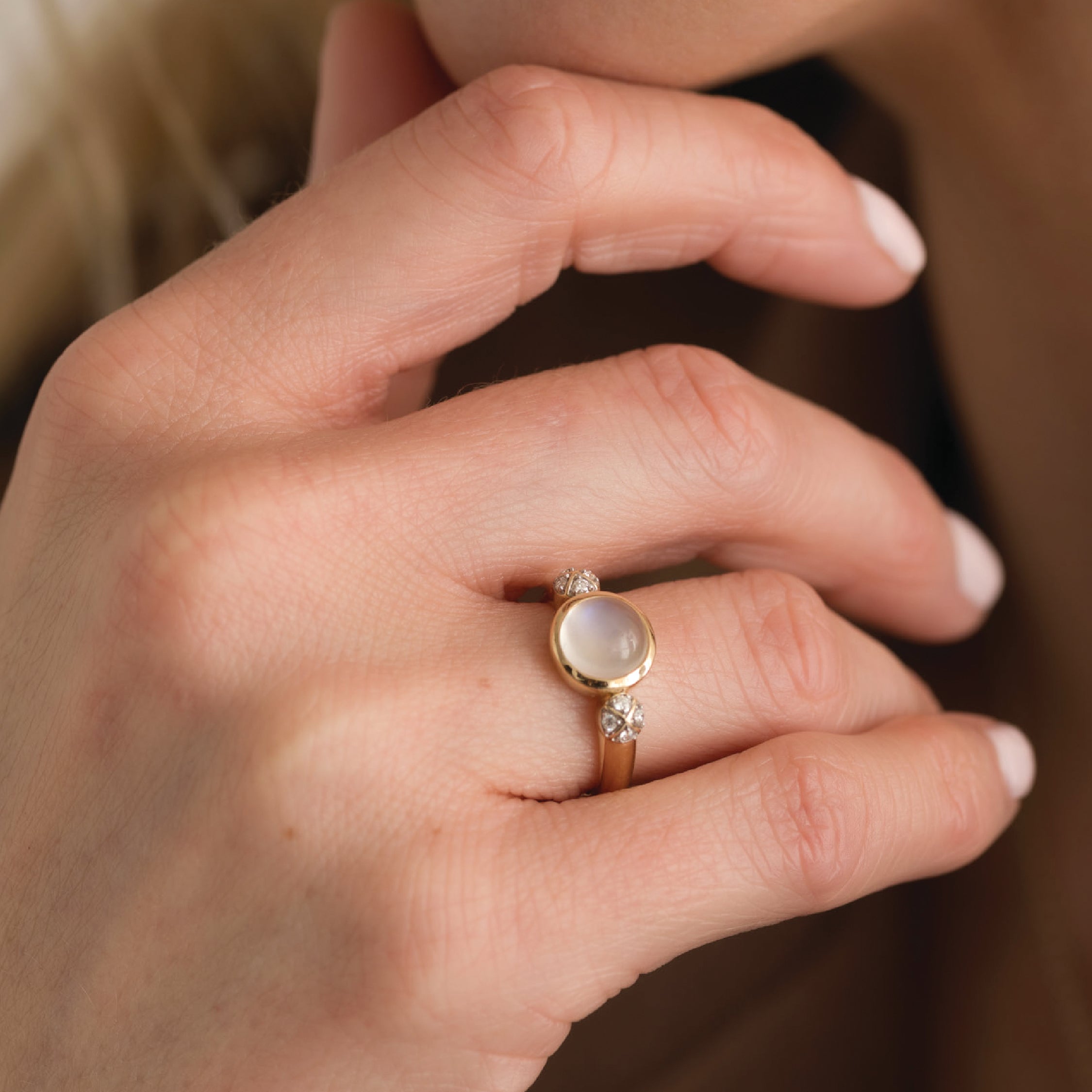 Opal and diamond ring in 14K gold on a hand, showcasing elegance and style.