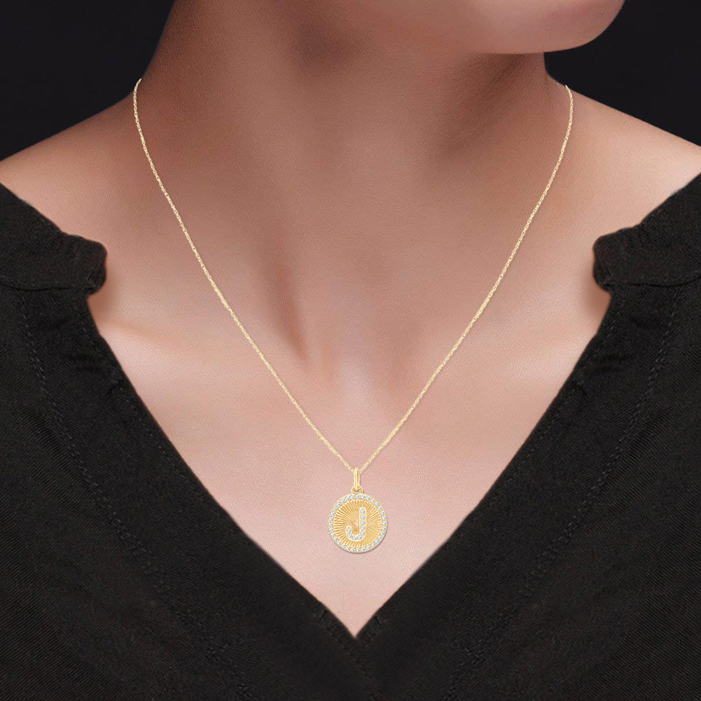 Gold necklace with a pendant on a person wearing a black top