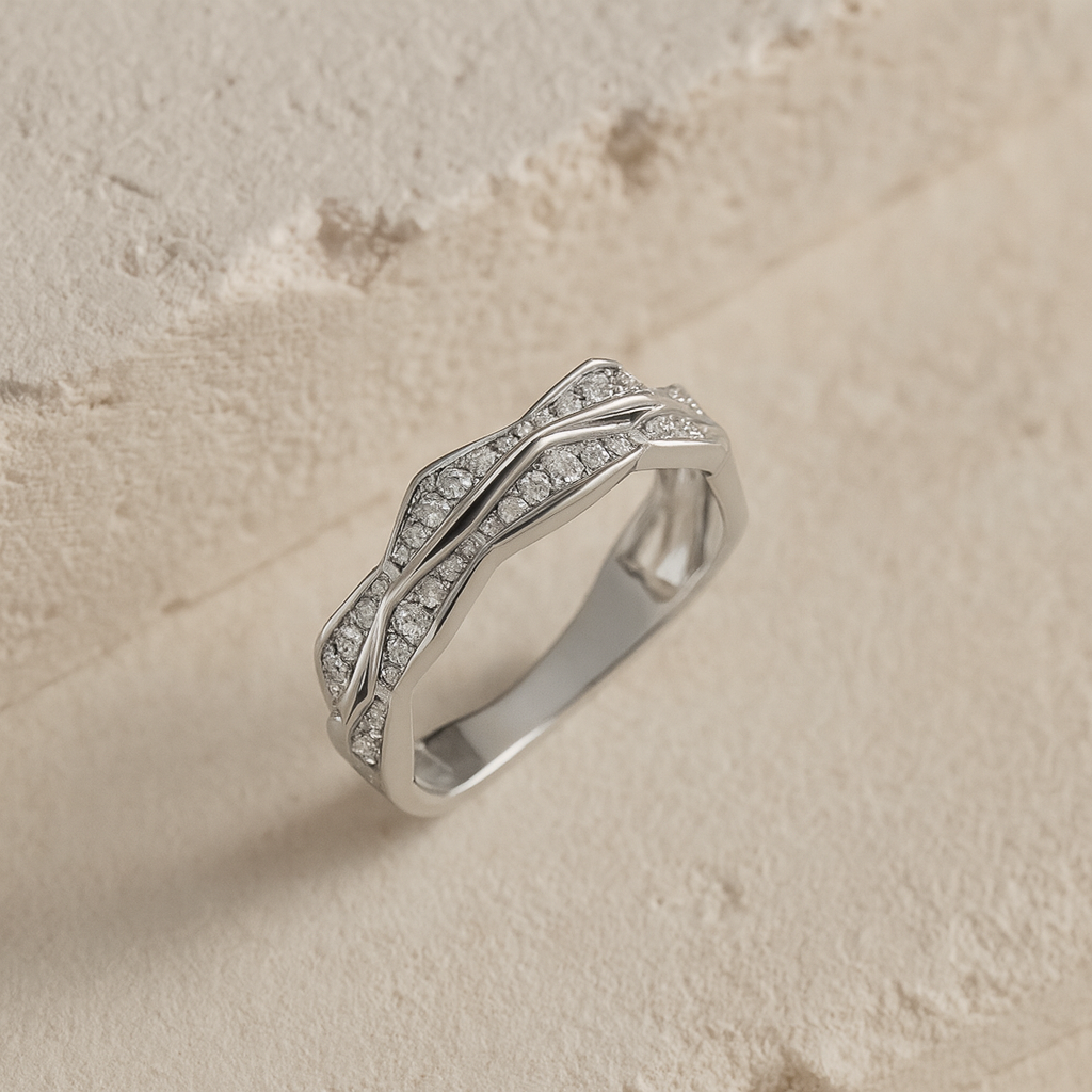Silver ring with diamond accents on a beige stone background