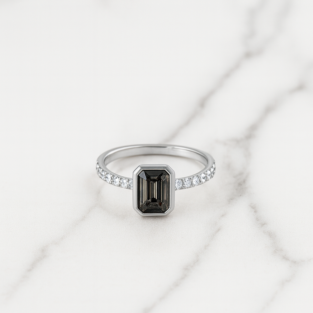 Silver ring with a black gemstone and diamond accents on a marble background