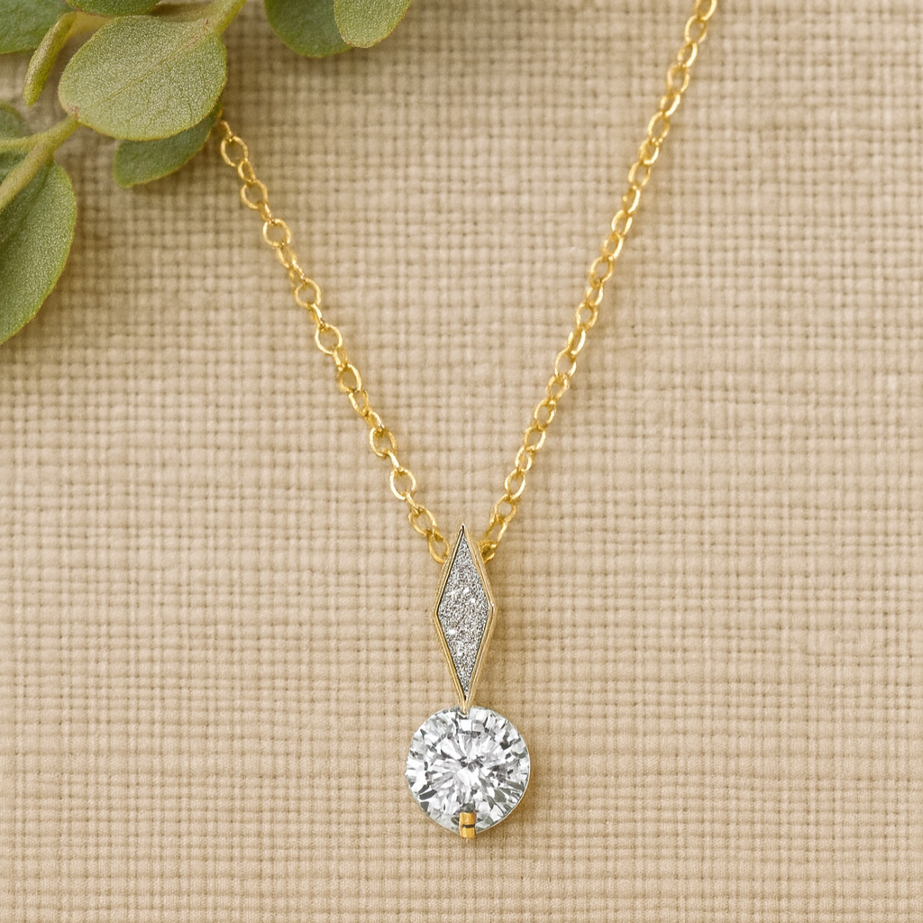 Gold necklace with a diamond pendant on a textured beige surface