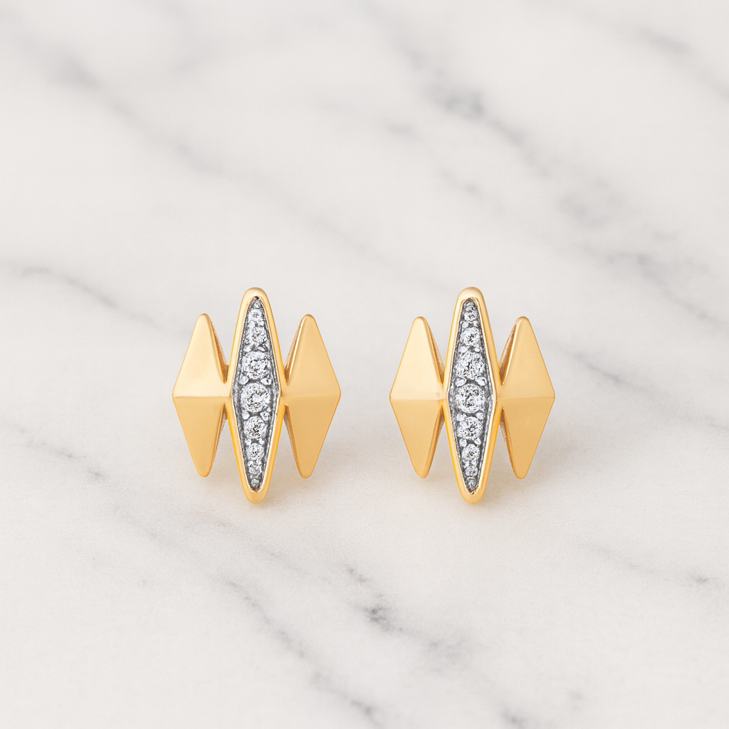 Gold earrings with diamond accents on a marble background