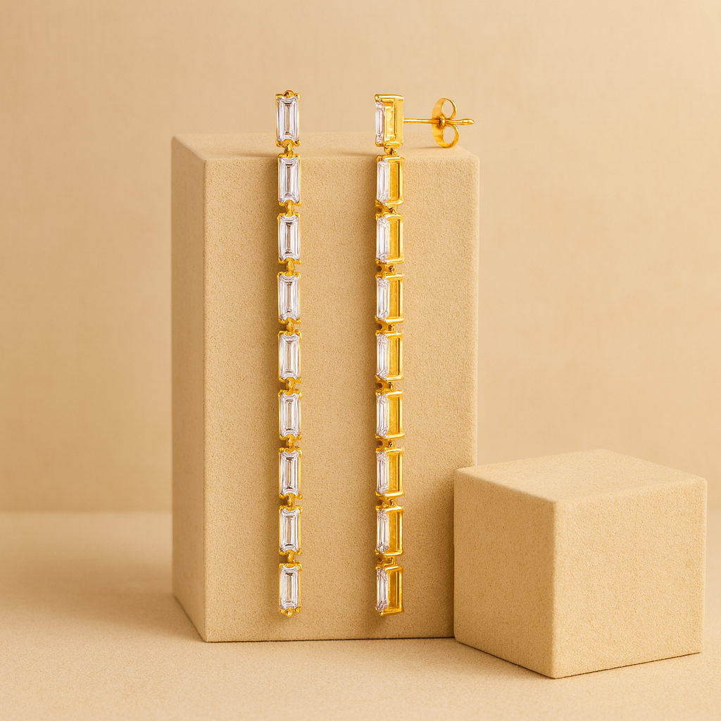 Gold earrings with clear stones on a beige background