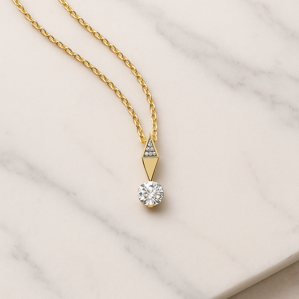 Gold necklace with a diamond pendant on a marble surface