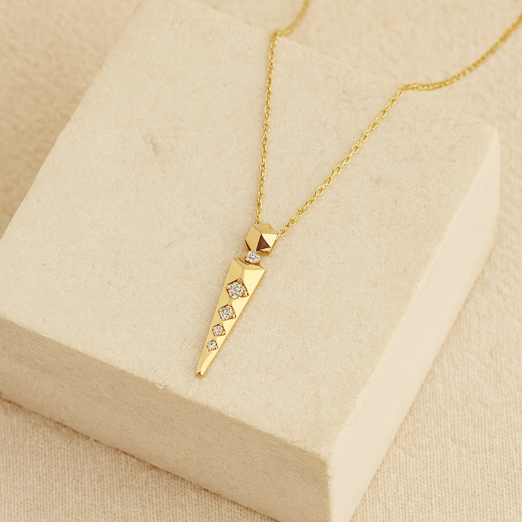 Gold necklace with a pendant on a beige display box