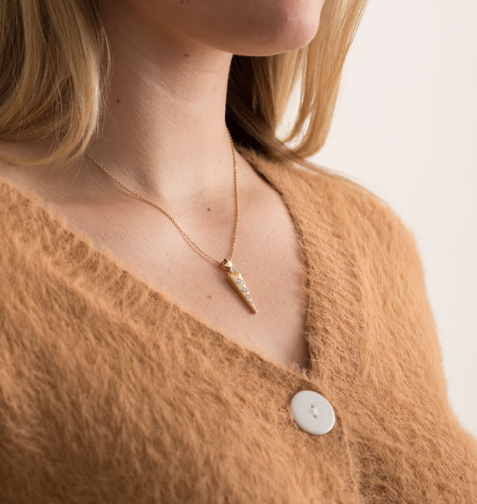 Model wearing a solid gold pendant necklace with lab ground diamonds