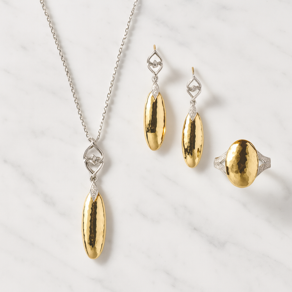 Gold and silver jewelry set including necklace, earrings, and ring on a light background