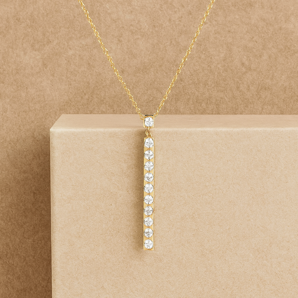 Gold necklace with a diamond pendant on a beige background