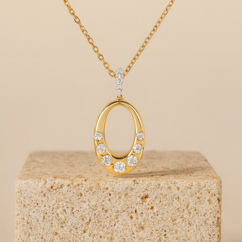 Gold necklace with an oval pendant on a beige block