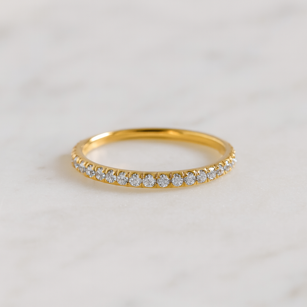 Gold ring with small diamonds on a light gray background