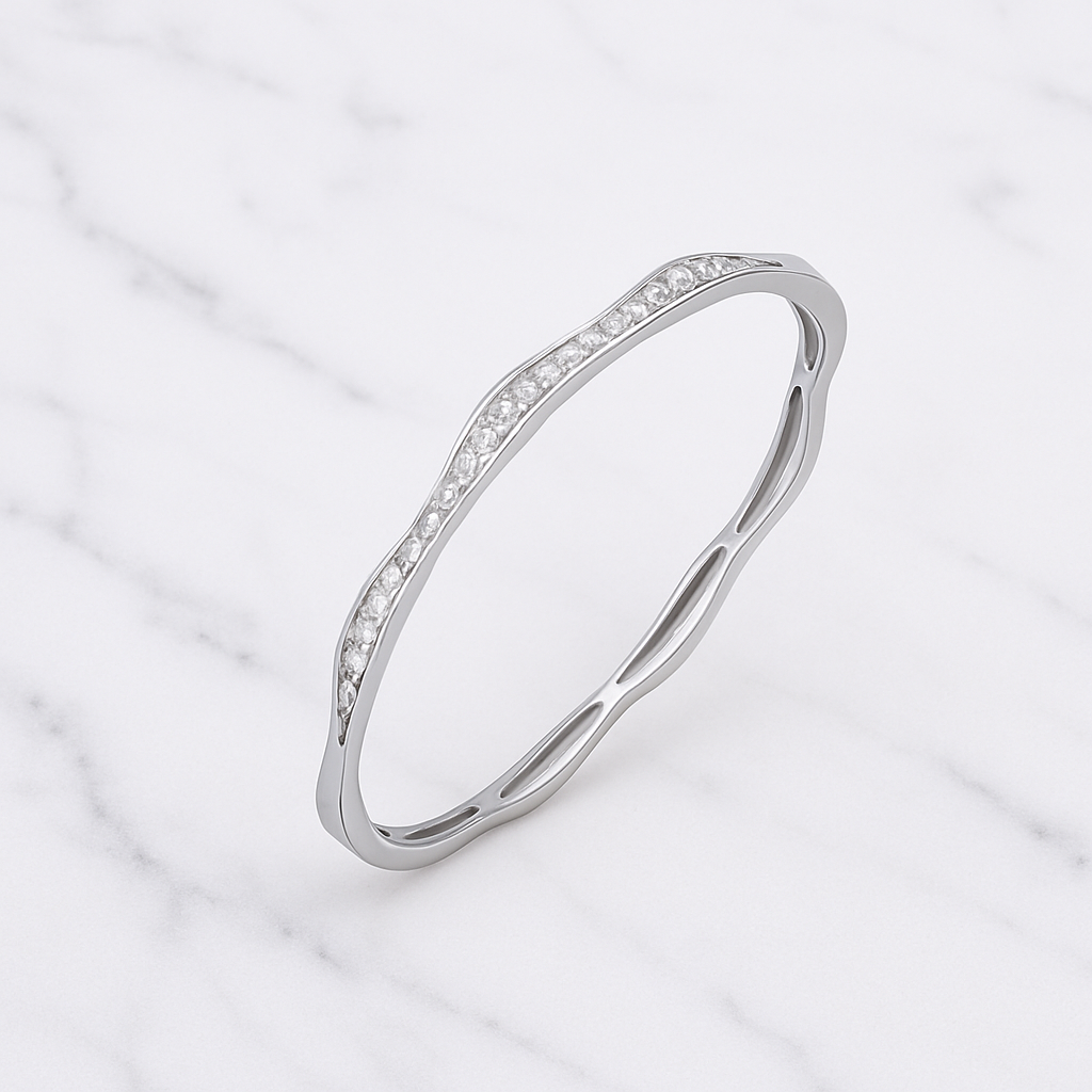 Silver bangle with small diamonds on a light marble background