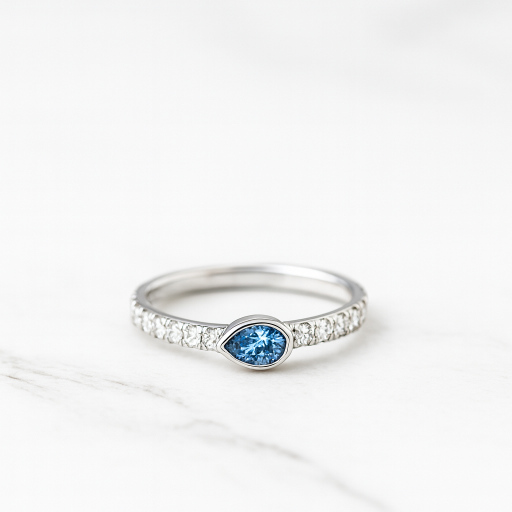 Silver ring with a blue gemstone on a white background