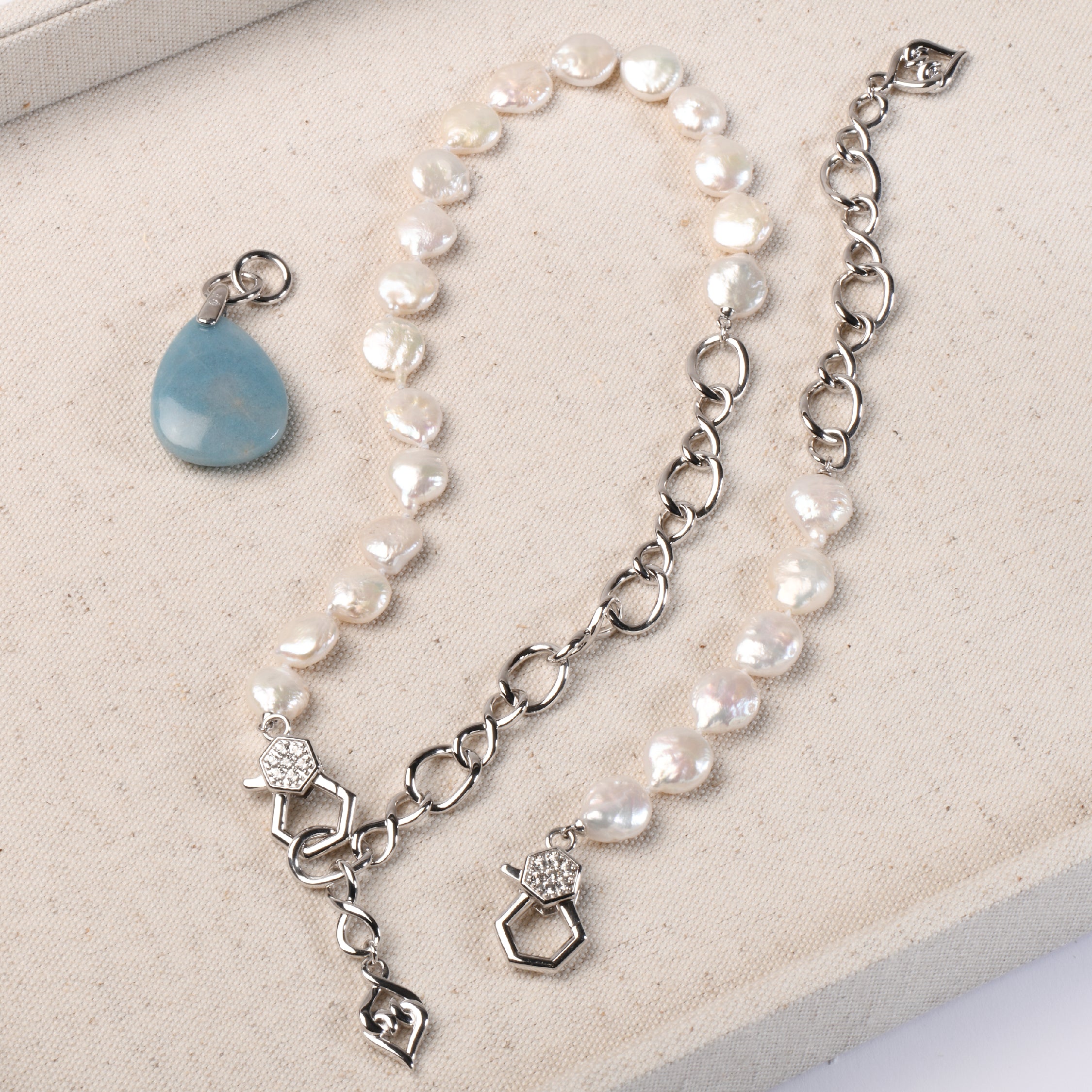 Sterling silver necklace with tear-shaped blue Paraiba quartz and pearl accents.